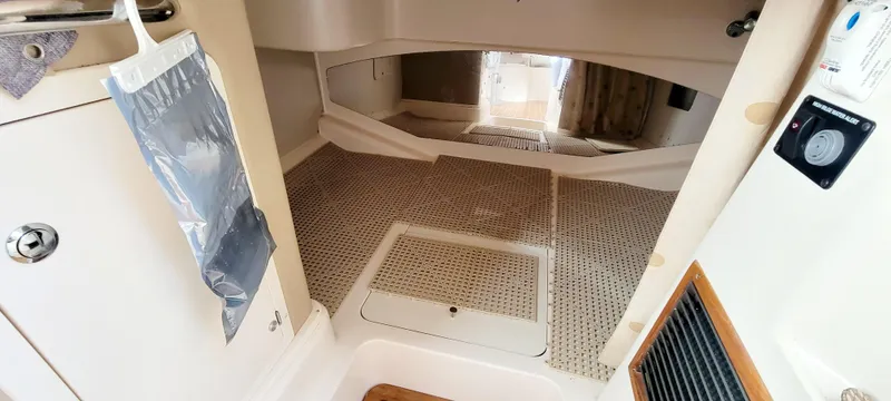 Slide: The Image of 2008 Grady-White 330 Express cabin interior with carpeted flooring and storage compartments. - 13