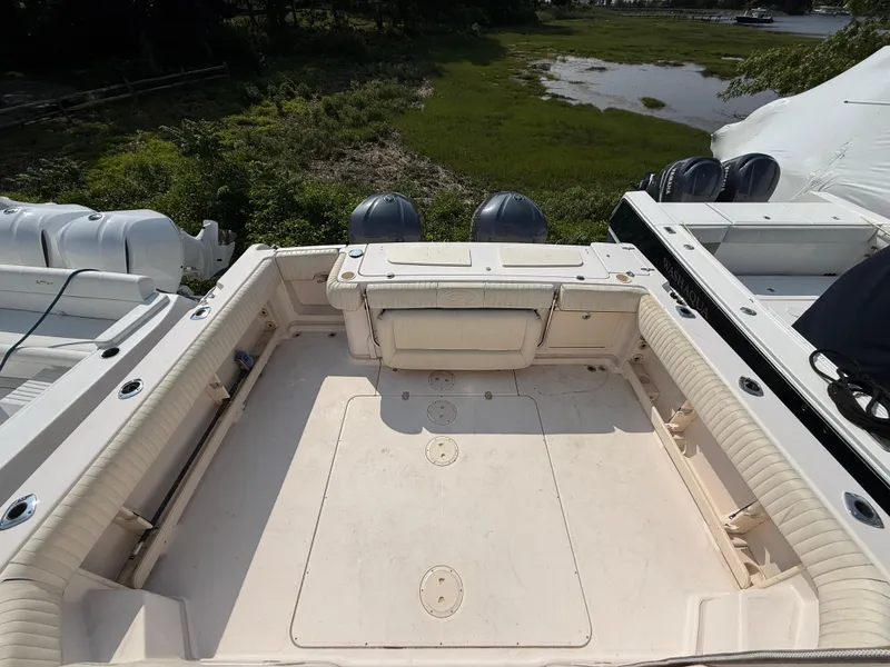 Slide: The Image of 2008 Grady-White 330 Express boat deck with dual engines, surrounded by greenery. - 17