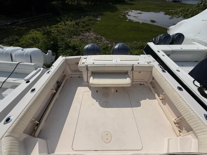 Slide: The Image of 2008 Grady-White 330 Express boat deck with seating, surrounded by lush greenery. - 18