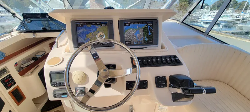 Slide: The Image of 2008 Grady-White 330 Express boat helm with dual navigation screens and steering wheel. - 2