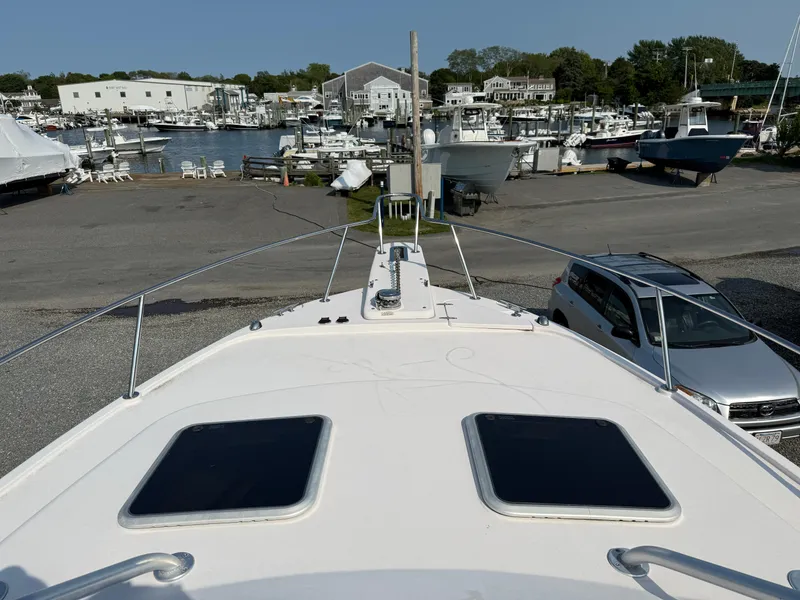 Slide: The Image of 2008 Grady-White 330 Express boat docked at a marina with nearby vehicles. - 24