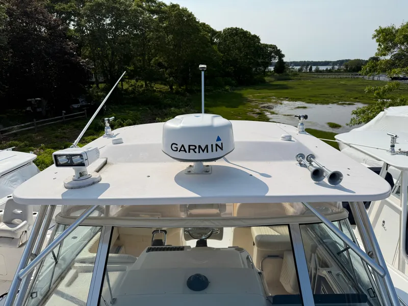 Slide: The Image of 2008 Grady-White 330 Express boat with Garmin radar, docked near lush greenery. - 26