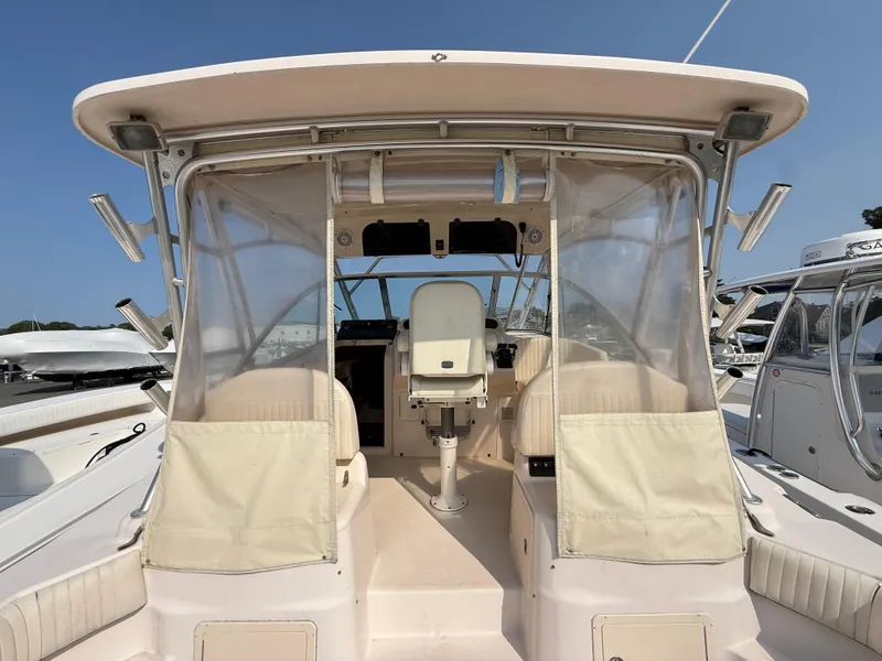 Slide: The Image of 2008 Grady-White 330 Express boat cockpit with seating and controls, docked under clear skies. - 28