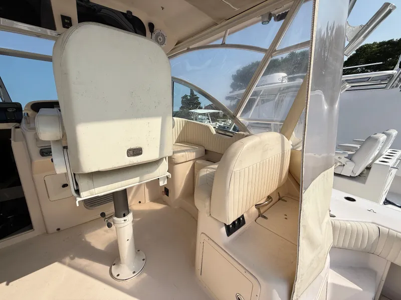 Slide: The Image of 2008 Grady-White 330 Express boat interior with helm seating and clear windows. - 29