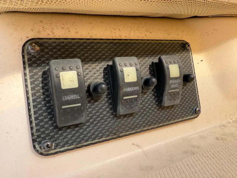 Slide: The Image of Control panel on a 2008 Grady-White 330 Express boat with switches for livewell, washdown, and spreader lights. - 30