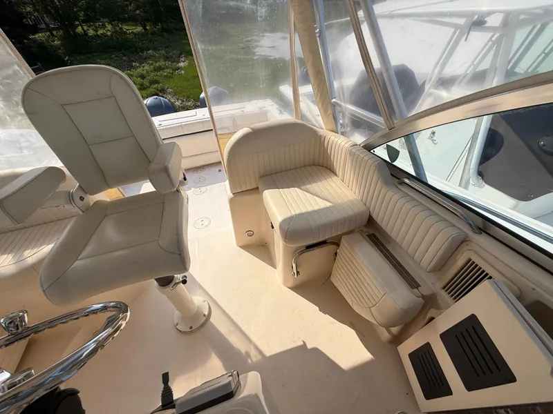 Slide: The Image of 2008 Grady-White 330 Express boat interior with cushioned seating and helm station. - 32