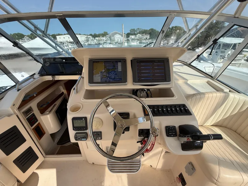 Slide: The Image of 2008 Grady-White 330 Express boat helm with dual screens and steering wheel. - 40