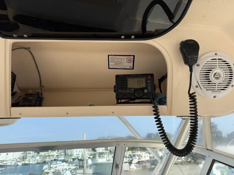 Slide: The Image of 2008 Grady-White 330 Express boat dashboard with radio and speaker, overlooking marina. - 45