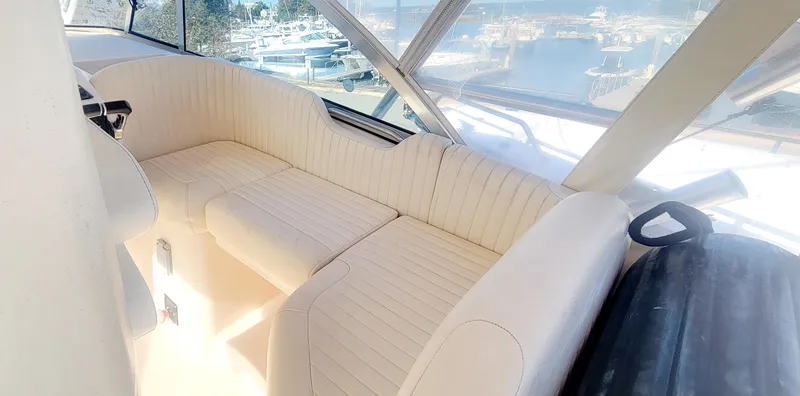 Slide: The Image of 2008 Grady-White 330 Express boat interior with beige seating and marina view. - 9