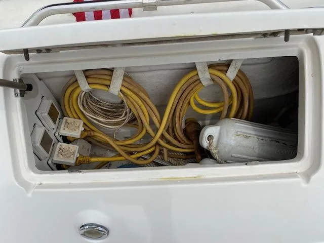 Slide: The Image of Storage compartment of 2006 Sea Ray Sundancer with coiled cables and fender. - 21