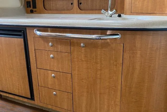 Slide: The Image of 2006 Sea Ray Sundancer kitchen area with wood cabinetry and sink. - 24