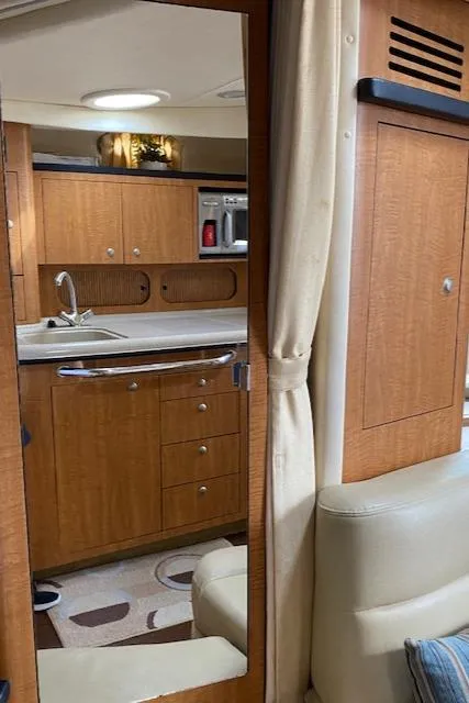Slide: The Image of Interior of 2006 Sea Ray Sundancer yacht with wooden cabinetry and modern kitchen amenities. - 31