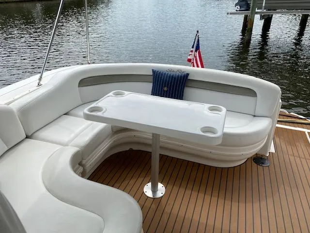 Slide: The Image of 2006 Sea Ray Sundancer boat with white seating and table on teak deck. - 6