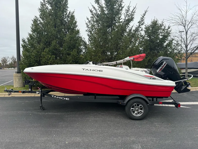 Slide: The Image of 2025 Tahoe T16 boat with red hull on trailer, parked outdoors. - 1