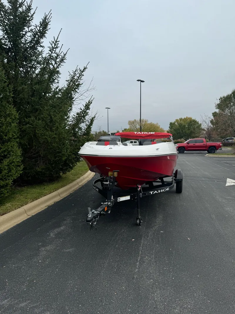 Slide: The Image of 2025 Tahoe T16 boat on trailer in parking lot, surrounded by trees. - 2