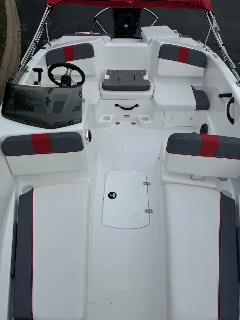 Slide: The Image of 2025 Tahoe T16 boat interior with red and gray seating, steering wheel, and storage compartments. - 4