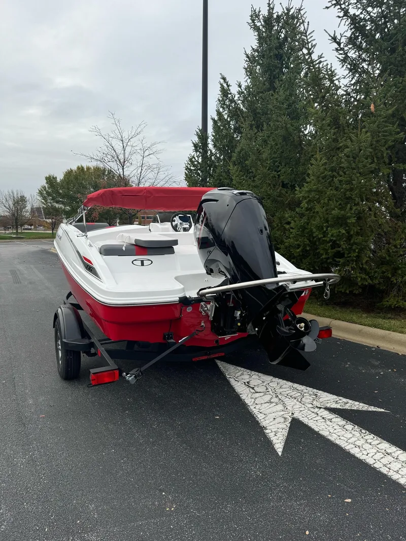 Slide: The Image of 2025 Tahoe T16 boat on trailer, red and white design, parked outdoors. - 5