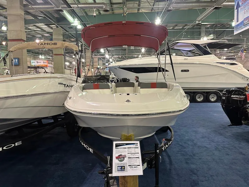 Slide: The Image of 2025 Tahoe T16 boat displayed indoors with red canopy and informational sign. - 3
