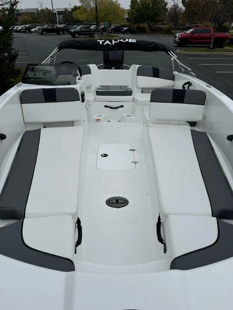 Slide: The Image of 2025 Tahoe T18 boat interior with white and gray seating in a parking lot. - 4