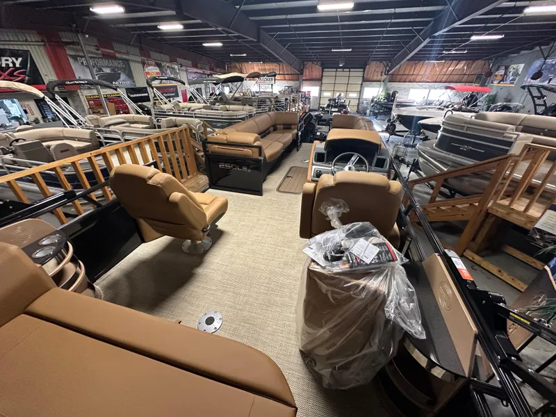Slide: The Image of 2025 Regency 250 LE3 Sport pontoon boat interior in showroom, featuring tan seating and modern design. - 8