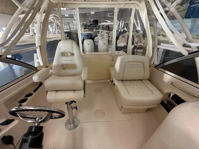 Slide: The Image of 2024 Grady-White 255 FREEDOM boat interior with plush seating and steering wheel. - 14
