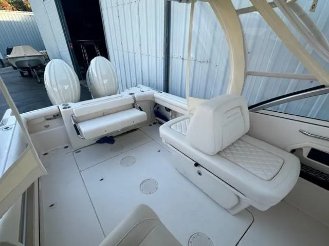 Slide: The Image of 2024 Grady-White 255 FREEDOM boat interior with white seating and dual engines. - 17