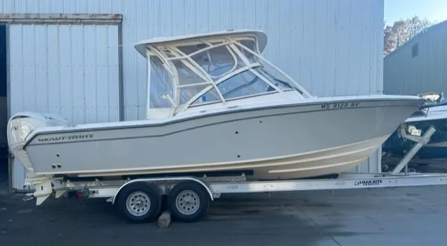 Slide: The Image of 2024 Grady-White 255 FREEDOM boat on trailer, parked outside a warehouse. - 2