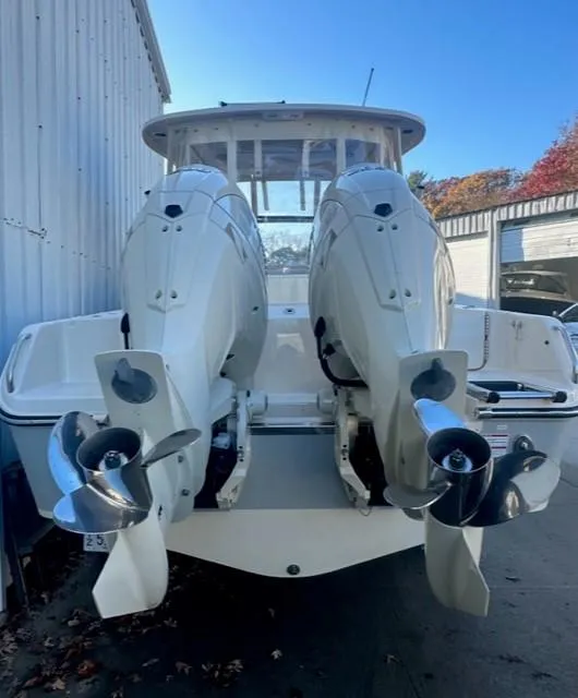 Slide: The Image of 2024 Grady-White 255 FREEDOM boat with dual outboard engines, docked outdoors. - 4