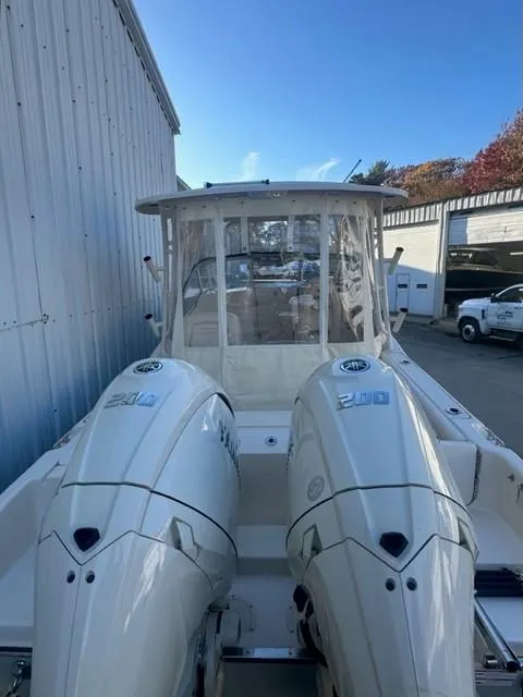 Slide: The Image of 2024 Grady-White 255 FREEDOM boat with dual engines, docked near a warehouse. - 5