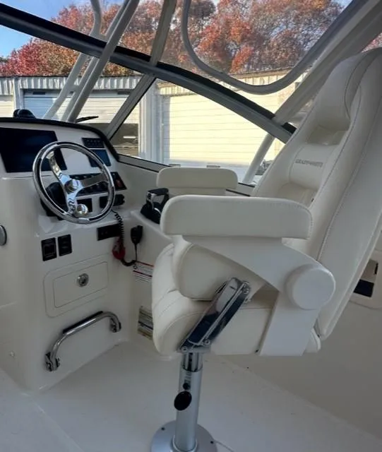 Slide: The Image of 2024 Grady-White 255 FREEDOM boat interior with captain's chair and steering wheel. - 9