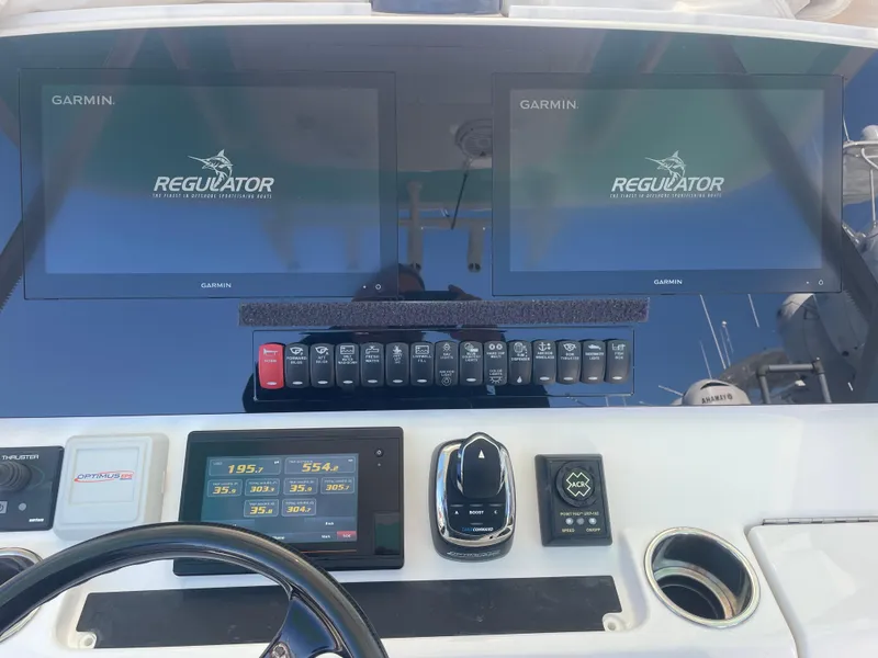 Slide: The Image of 2019 Regulator 34 boat dashboard with dual Garmin displays and control panel. - 14