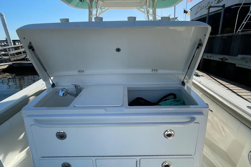 Slide: The Image of 2019 Regulator 34 boat with open storage compartment and sink. - 29