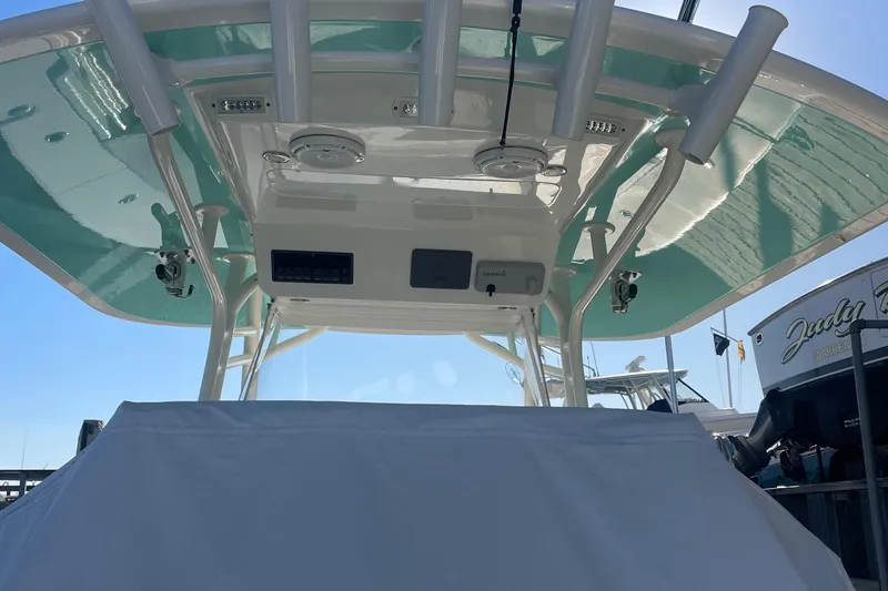 Slide: The Image of 2019 Regulator 34 boat with covered helm and T-top, docked under clear sky. - 30