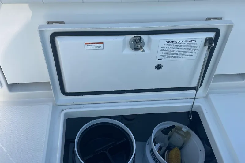 Slide: The Image of 2019 Regulator 34 boat storage compartment with cleaning supplies. - 32