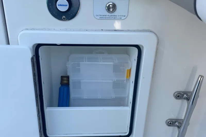 Slide: The Image of Storage compartment on a 2019 Regulator 34 boat with tackle box and blue container. - 33