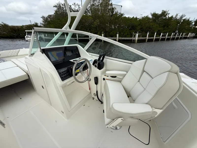 Slide: The Image of 2025 World Cat 230 SD boat cockpit with steering wheel and comfortable seating. - 12
