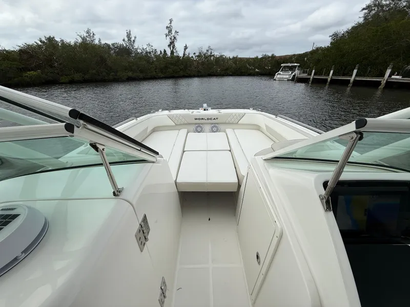 Slide: The Image of 2025 World Cat 230 SD boat on a calm river, surrounded by lush greenery. - 14
