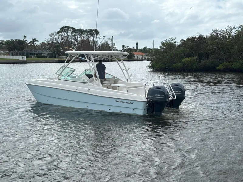 Slide: The Image of 2025 World Cat 230 SD boat cruising on a calm river with lush greenery. - 4