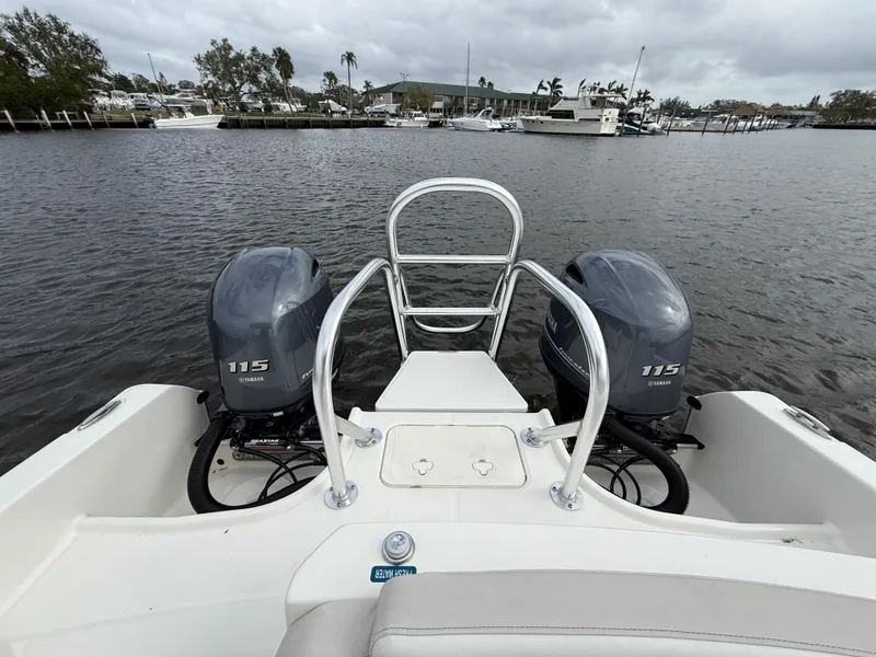 Slide: The Image of 2025 World Cat 230 SD boat with dual 115 Yamaha engines on a calm waterway. - 7