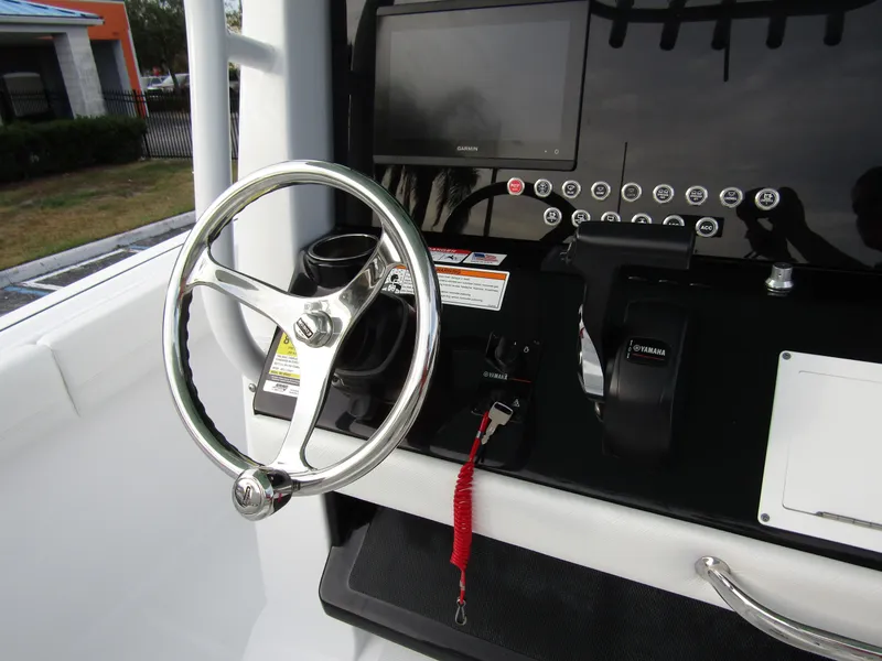 Slide: The Image of 2025 Wellcraft 223 Fisherman boat dashboard with steering wheel and controls. - 21