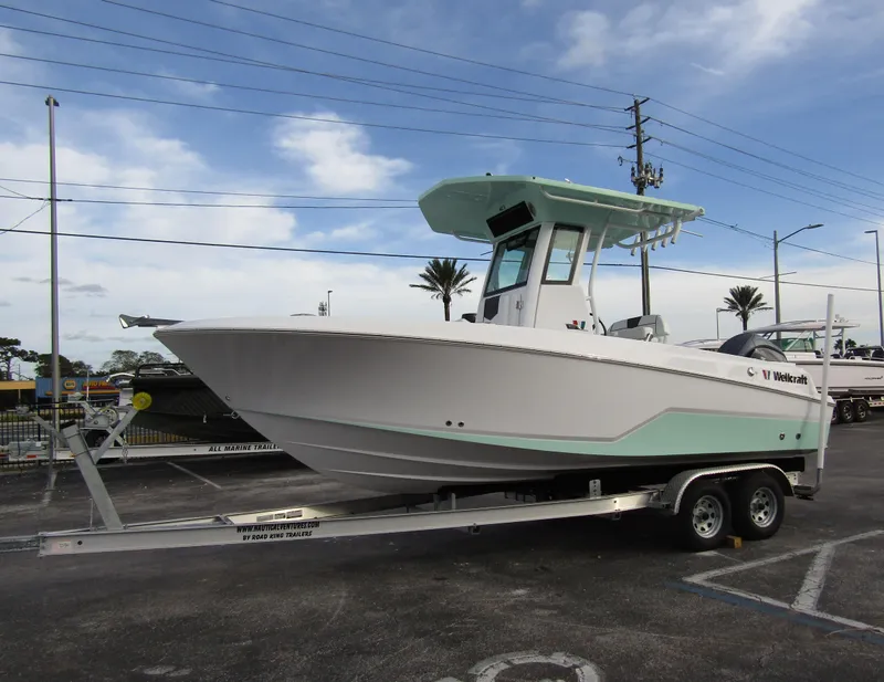 Slide: The Image of 2025 Wellcraft 223 Fisherman boat on trailer, parked outdoors under a cloudy sky. - 5