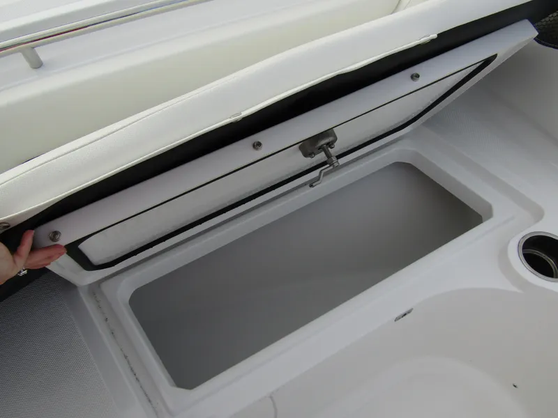 Slide: The Image of 2025 Wellcraft 223 Fisherman storage compartment with open lid and cup holder. - 9