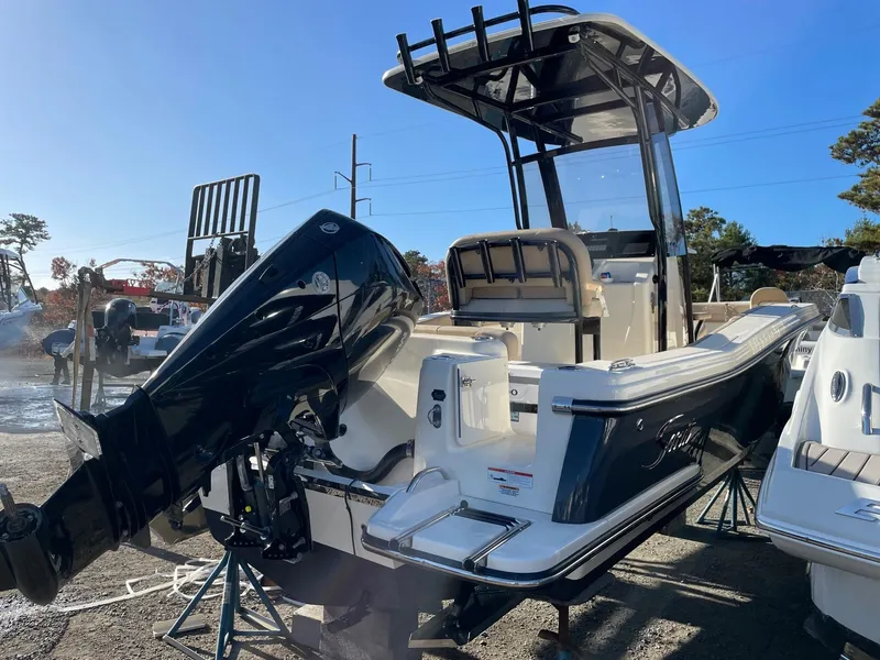 Slide: The Image of 2023 Scout 215 XSF boat with powerful outboard motor in a sunny outdoor setting. - 3