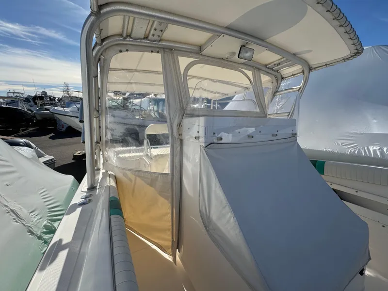 Slide: The Image of 1999 Marlin 350 SF boat with covered cockpit, docked under clear skies. - 15