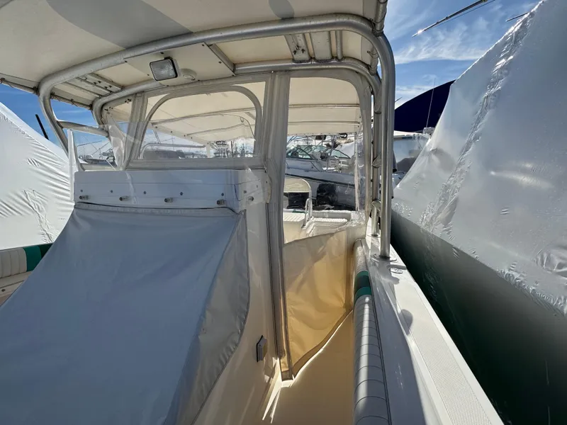 Slide: The Image of 1999 Marlin 350 SF boat with covered seating and canopy, docked under clear skies. - 16