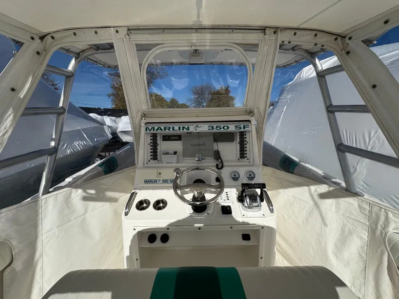 Slide: The Image of Interior view of 1999 Marlin 350 SF boat cockpit with steering wheel and controls. - 17