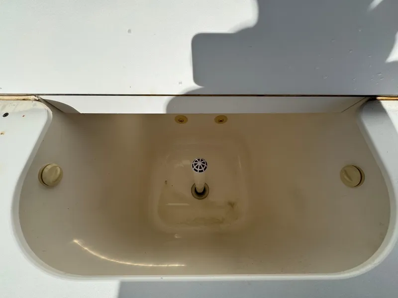 Slide: The Image of 1999 Marlin 350 SF boat livewell with drain plug and lid. - 21