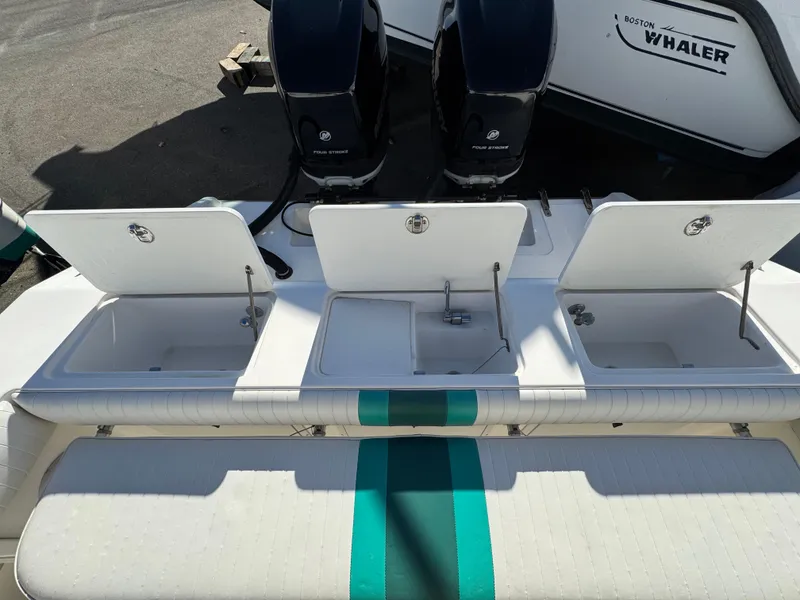 Slide: The Image of 1999 Marlin 350 SF boat with open storage compartments and dual outboard motors. - 23