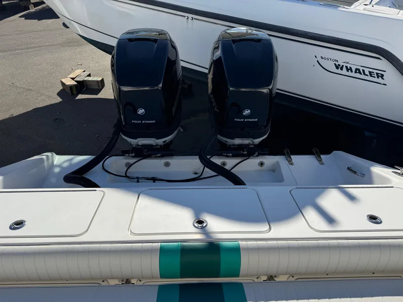 Slide: The Image of 1999 Marlin 350 SF boat with twin outboard engines, docked beside a Boston Whaler. - 27
