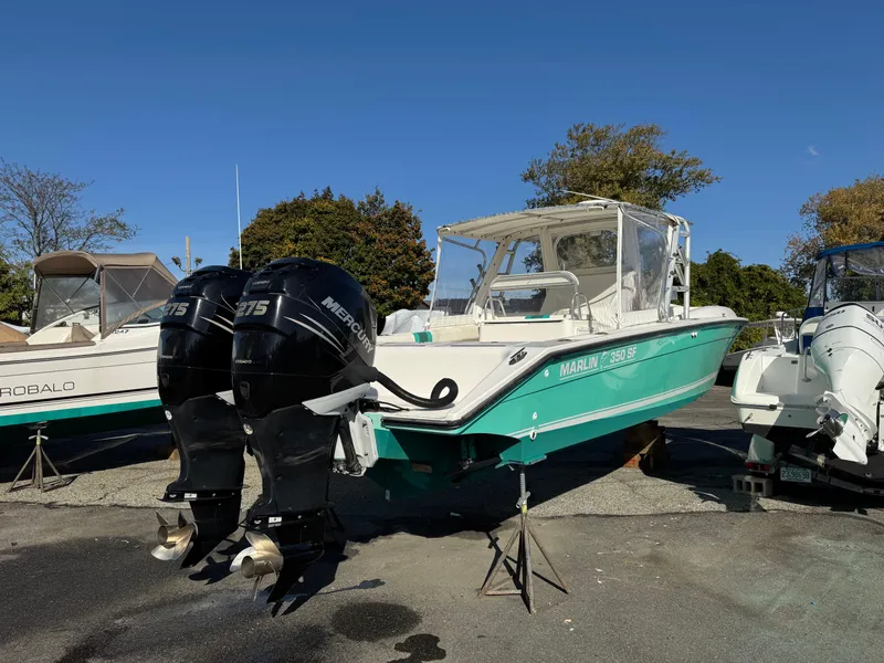 Slide: The Image of 1999 Marlin 350 SF boat with twin Mercury outboard engines, parked on a sunny day. - 3